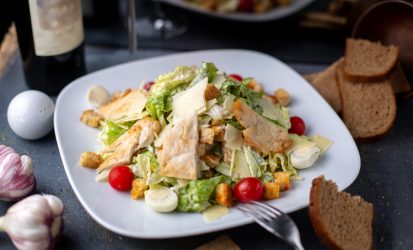 sliced-chicken-pieces-along-with-fresh-vegetables-red-wine-inside-white-plate